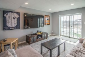 Hockey Enthusiasts Dream Basement with an Area for Games and Movie Time