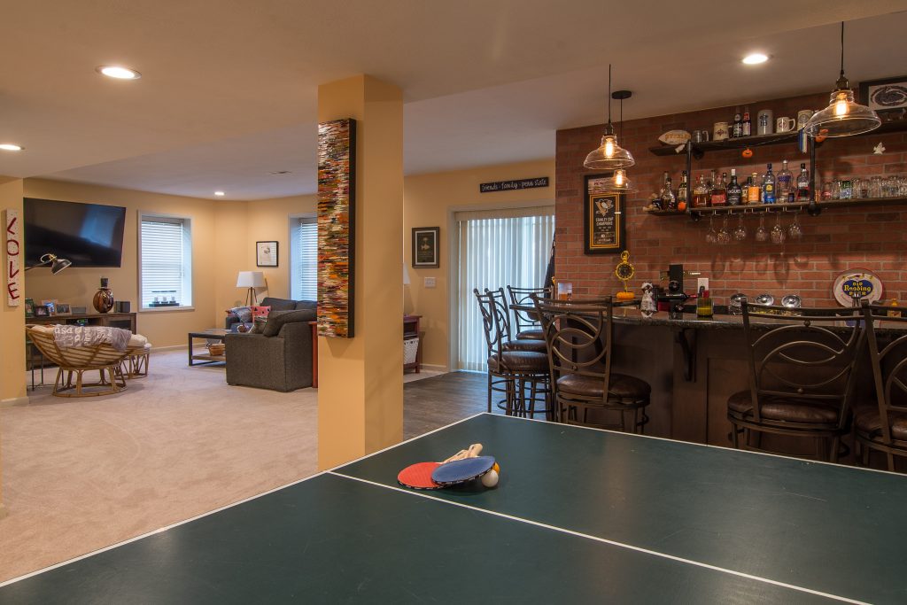 Transforming a Monroeville Basement into a New Entertainment Area with Lighter and Darker Warm Tone.