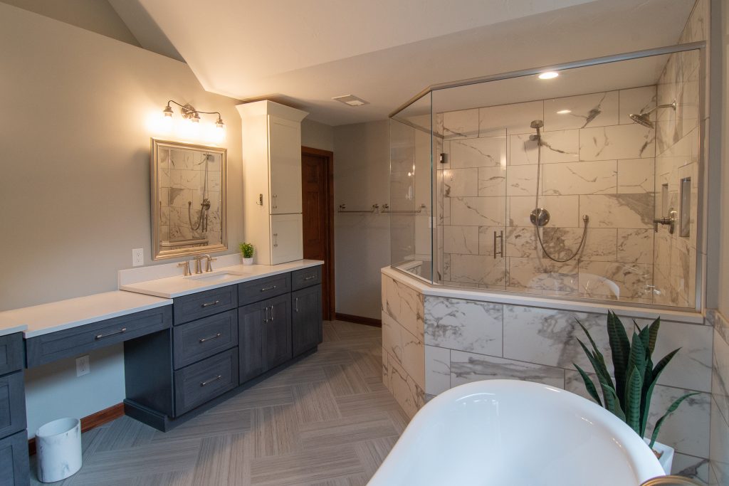 Picture of a traditional-style master bathroom in Cranberry, PA, using a mix of warm and cold tones that accent the walk-in shower and standalone tub.