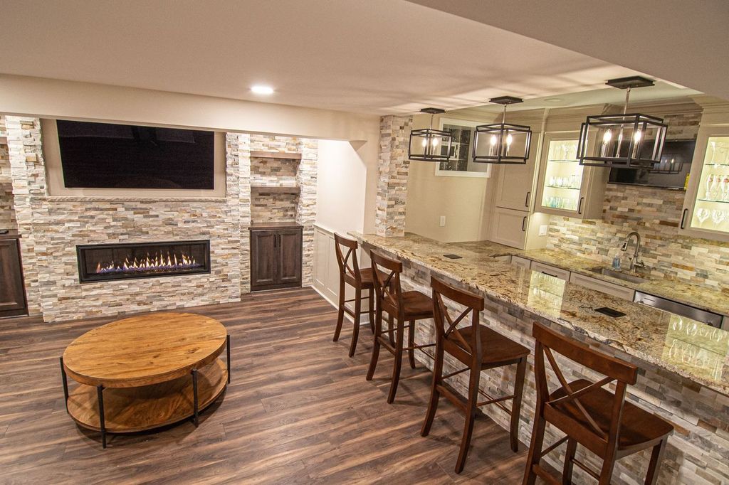 Picture of a modern Upper St. Clair, PA, basement showing warm colors, straight-lined cabinets, and stacked stone.