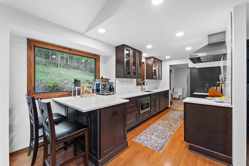 This Classic Cranberry Modern Kitchen with Dark Wood Cabinets and Rich Espresso Finishes Combine Natural Elements Like Wood and Light to Create a Touch of Warmth.