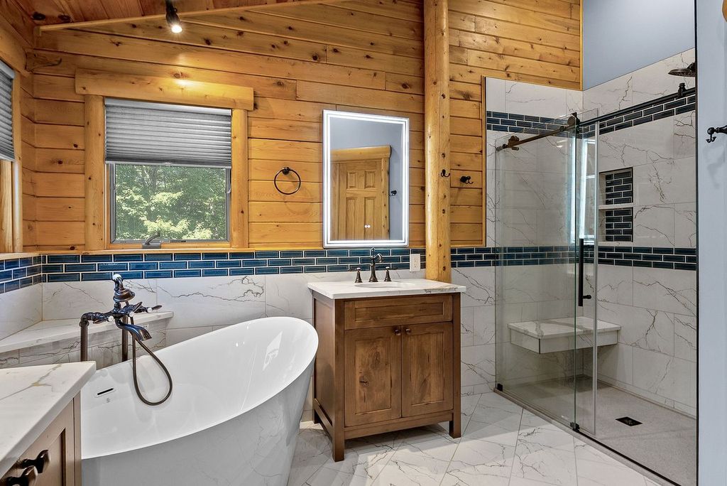 Transitional Style Squirrel Hill Bathroom with Free Standing Tub, Glass-Enclosed Shower and Marble Flooring Incorporates a Blend of Rustic and Traditional Features to Create a Relaxing Spa-Like Atmosphere.