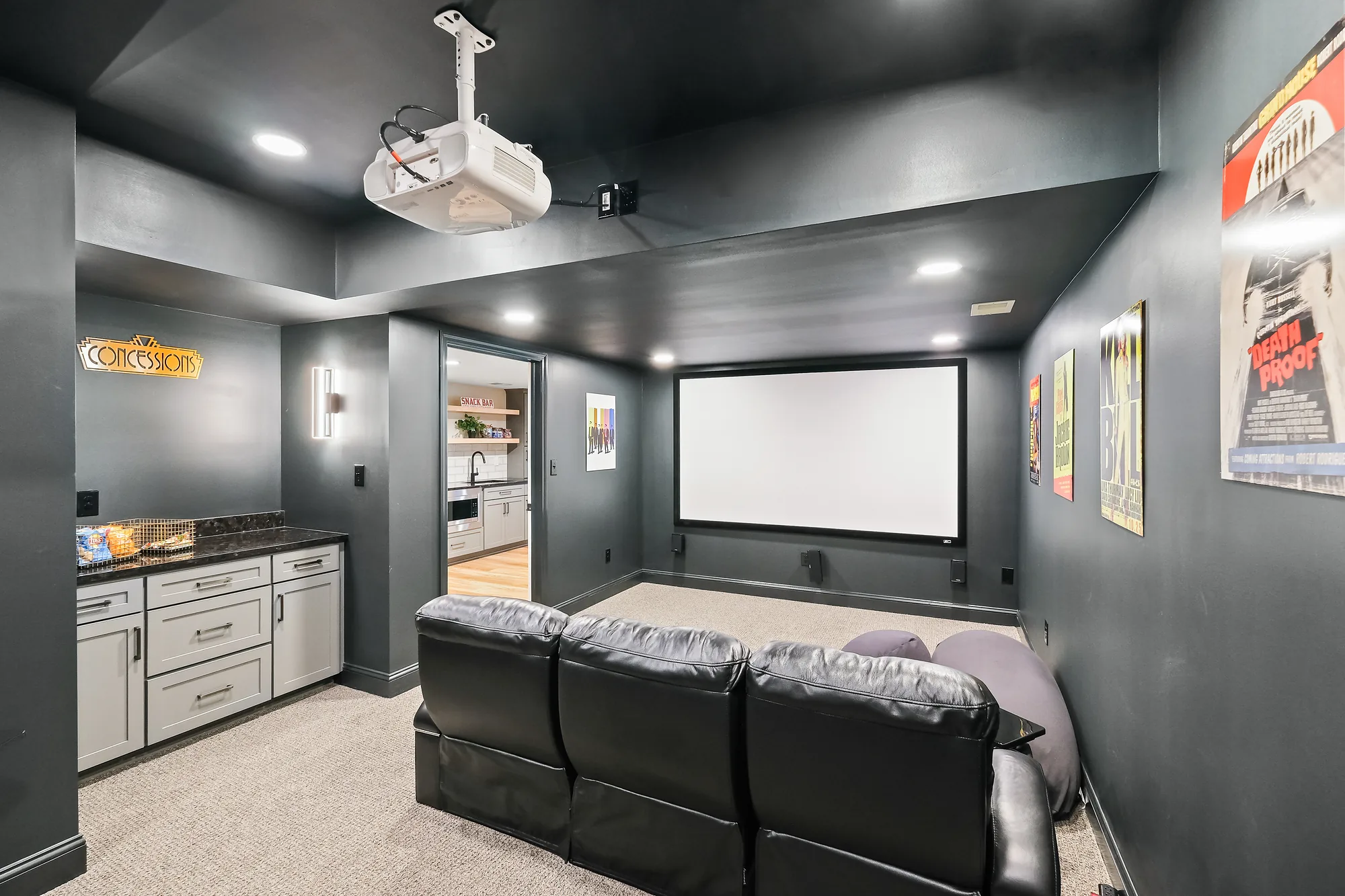 Stylish and Cozy Murrysville Home Mov
ie Theater with Large Screen, Black Leather
Couch, Cabinetry, Dark Walls and Light Carpet Creating an Intimate Setting
