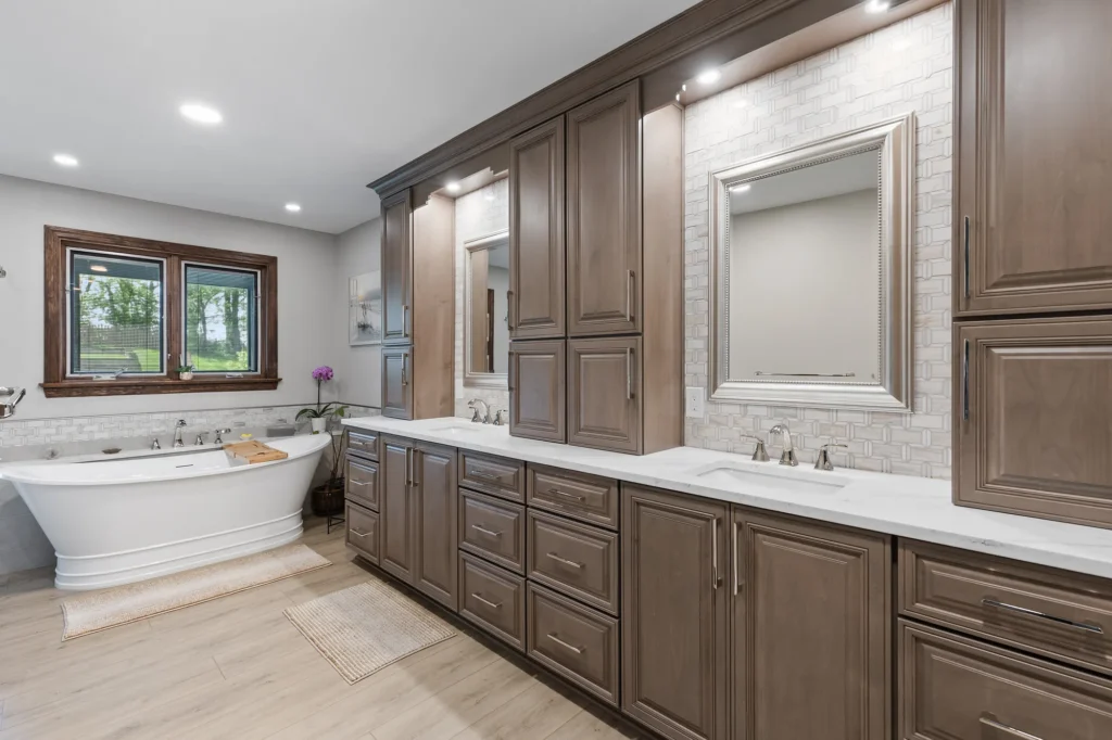 Traditional McMurray bathroom featuring honey-toned wood cabinetry, long double vanity, light quartz countertops, neutral tile walk-in shower with glass enclosure.
