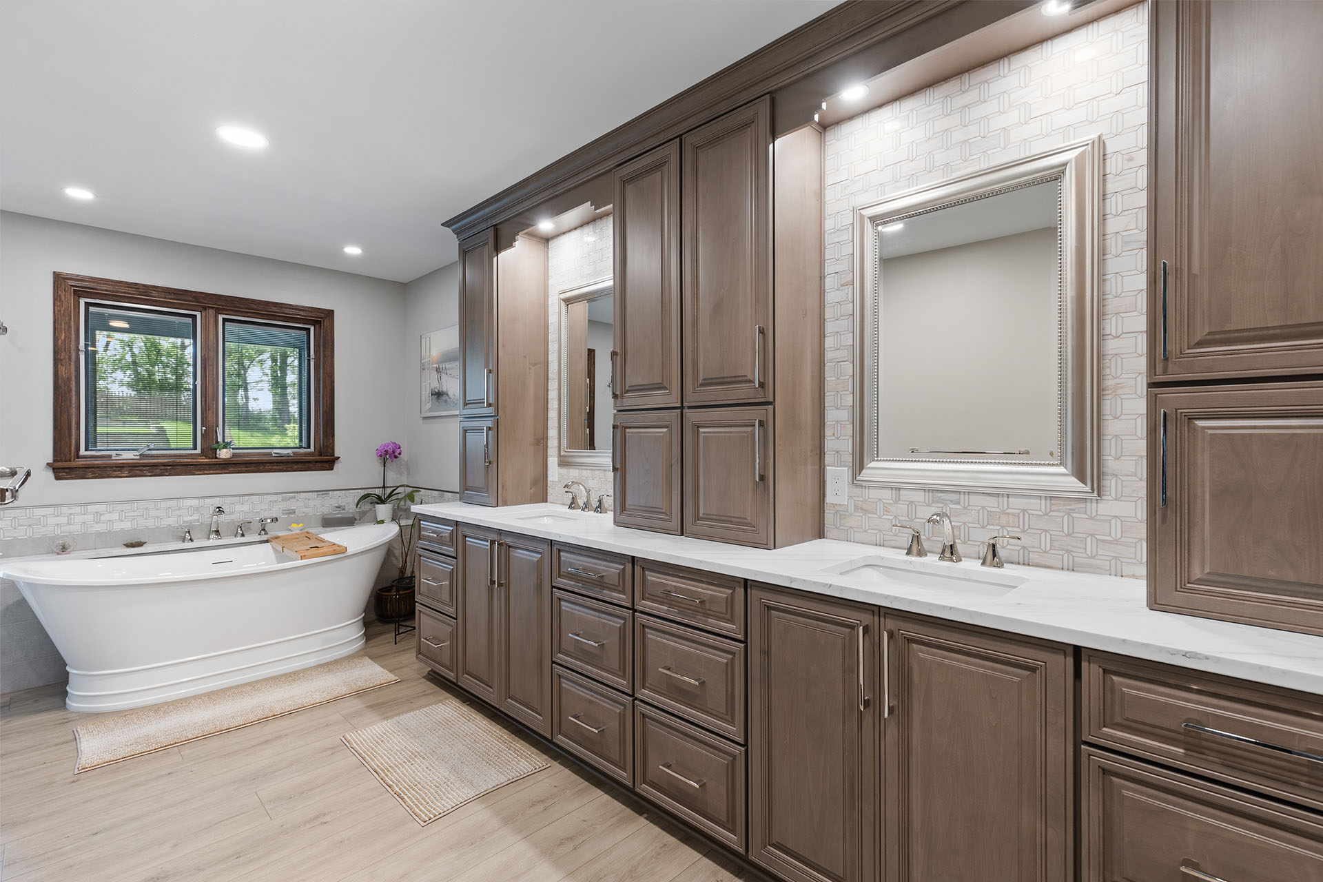 Traditional Style McMurray Bathroom with Stained Raised Panel Cabinets, White Quartz Countertops, Cool Grey Marble Backsplash and Freestanding Soaking Tub