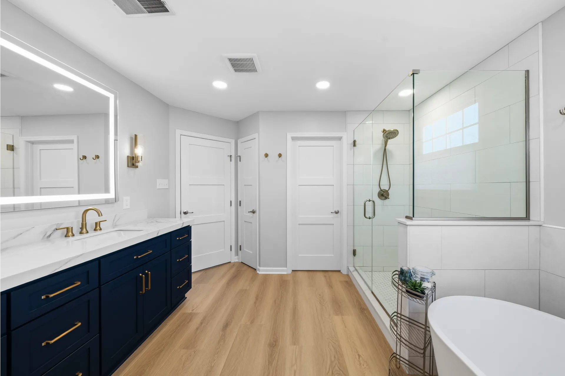 Contemporary Gibsonia Master Bathroom with Dark Blue Shaker-Style Vanity, White Quartz Countertops with Grey Veining and White Tile Shower with Hexagon Mosaic Floor