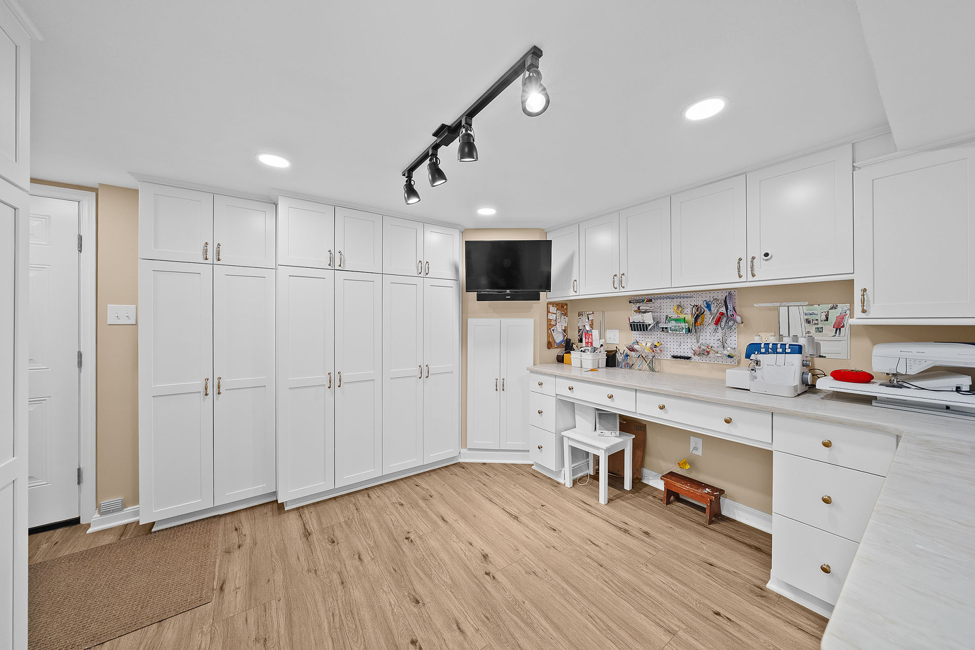 Ross Twp Custom Craft Room with Walls of Tall, Built-In White Cabinetry Offers Extensive Storage for Supplies, Materials and Tools