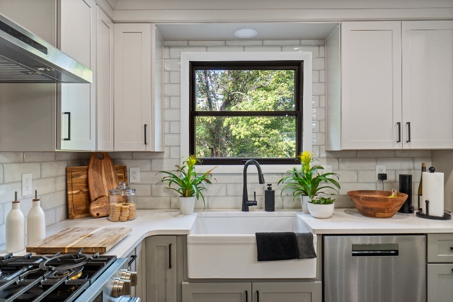 Murrysville kitchen sink framed by light gray shaker cabinets, white quartz counters, and a white subway tile backsplash.