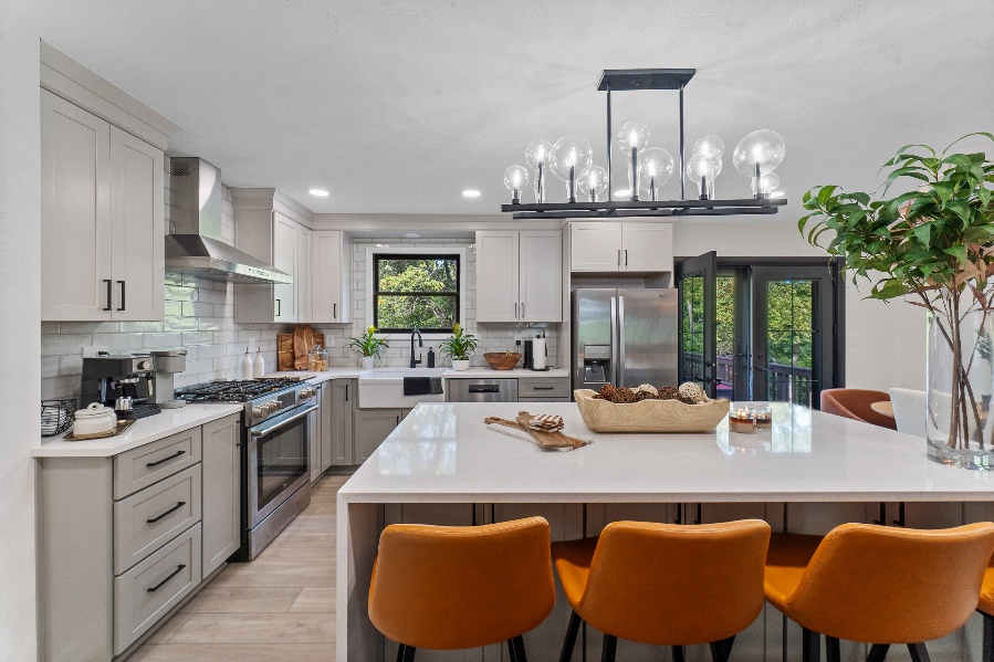 Wide view of the remodeled Murrysville kitchen with quartz island, gray cabinetry, and patio doors.