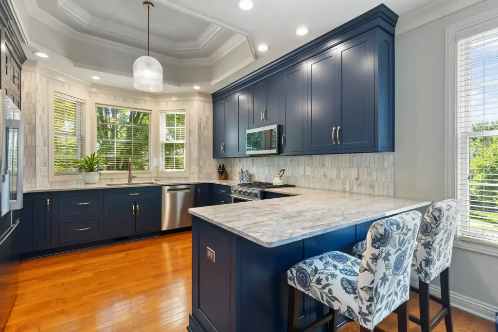 Transitional Sewickley Kitchen with Shaker-Style Cabinets in a Navy Blue Paint, Quartz Countertops with Warm Grey and Beige Veining.