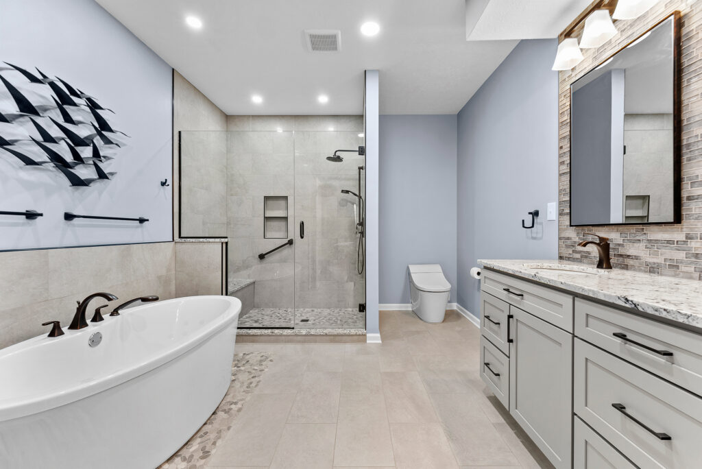 Contemporary Squirrel Hill Master Bathroom with Modern Spa-Inspired Style Featuring a Freestanding Soaking Tub with Sleek Dark Fixtures and Frameless Glass Walk-In Shower.