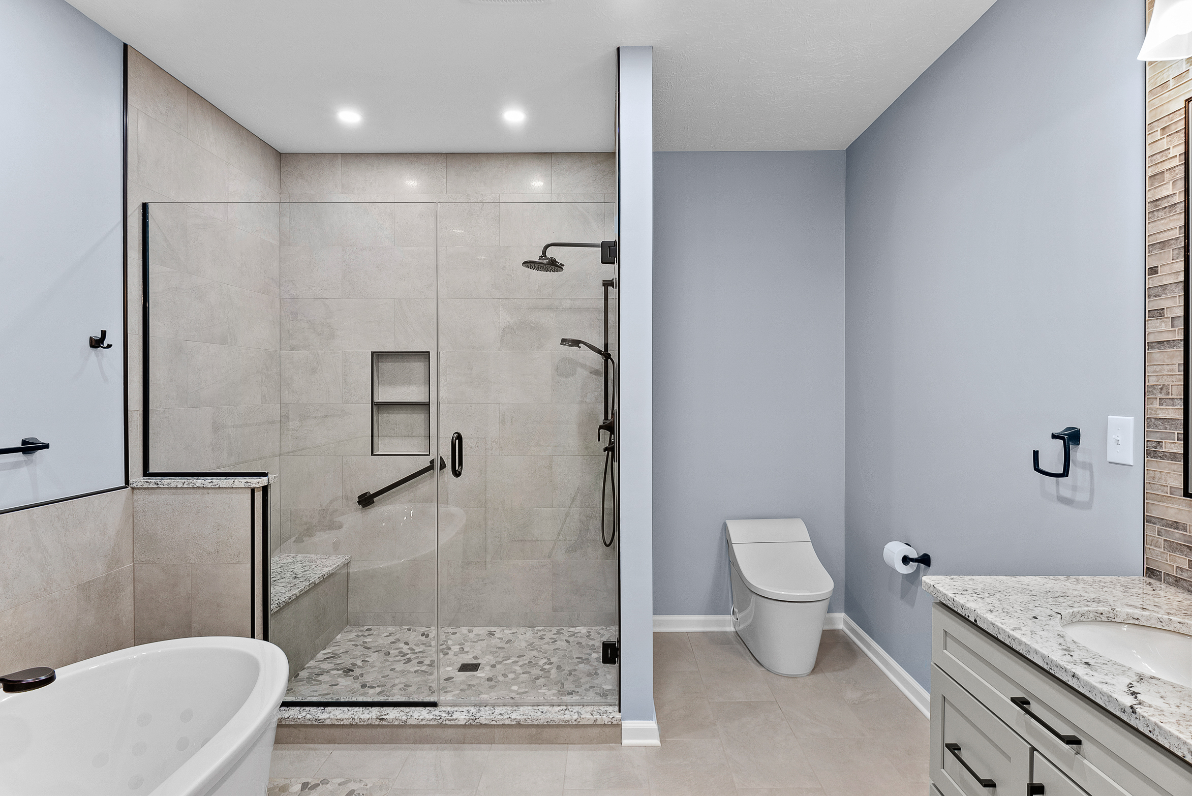 Contemporary Squirrel Hill Master Bathroom with Modern Spa-Inspired Style Featuring a Freestanding Soaking Tub with Sleek Dark Fixtures and Frameless Glass Walk-In Shower